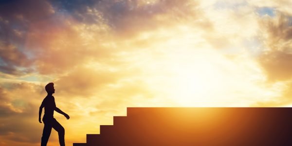 Man standing in front of stairs. Aspiration and ambition. Overcoming obstacles.